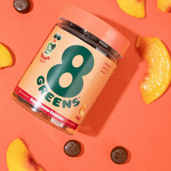 8Greens Supergreens Gummies on countertop with glass of water