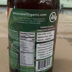 Amenazel Moringa Bitters glass with bottle and herbs conveys natural wellness.