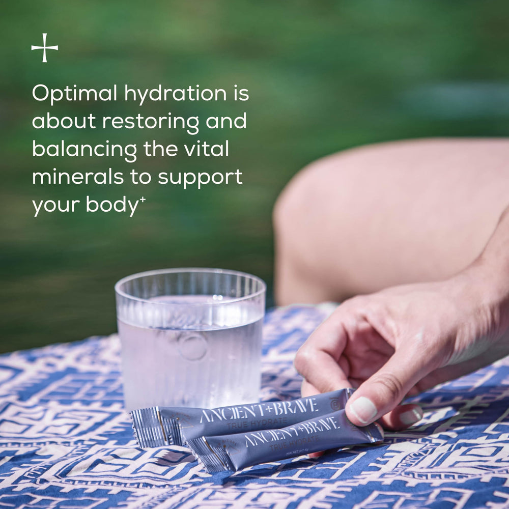 Ancient Brave True Hydration Powder packet ready to be poured, ideal for travel days.