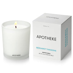 APOTHEKE Bergamot Tangerine candle in glass jar enhances living room ambiance.