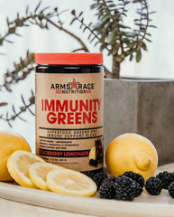 Arms Race Nutrition Immunity Greens bottle side label listing vitamins, minerals, and probiotic benefits.