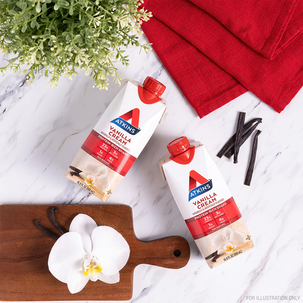 Atkins Vanilla Cream Shake glass pour, creamy vanilla flavor ready to enjoy.