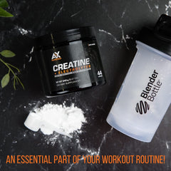 AX Nutrition Creatine + Electrolytes scoop in a glass of water for fast, convenient blending.