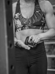 Athlete using BloQaid Callus Rx during lifting to smooth hands.