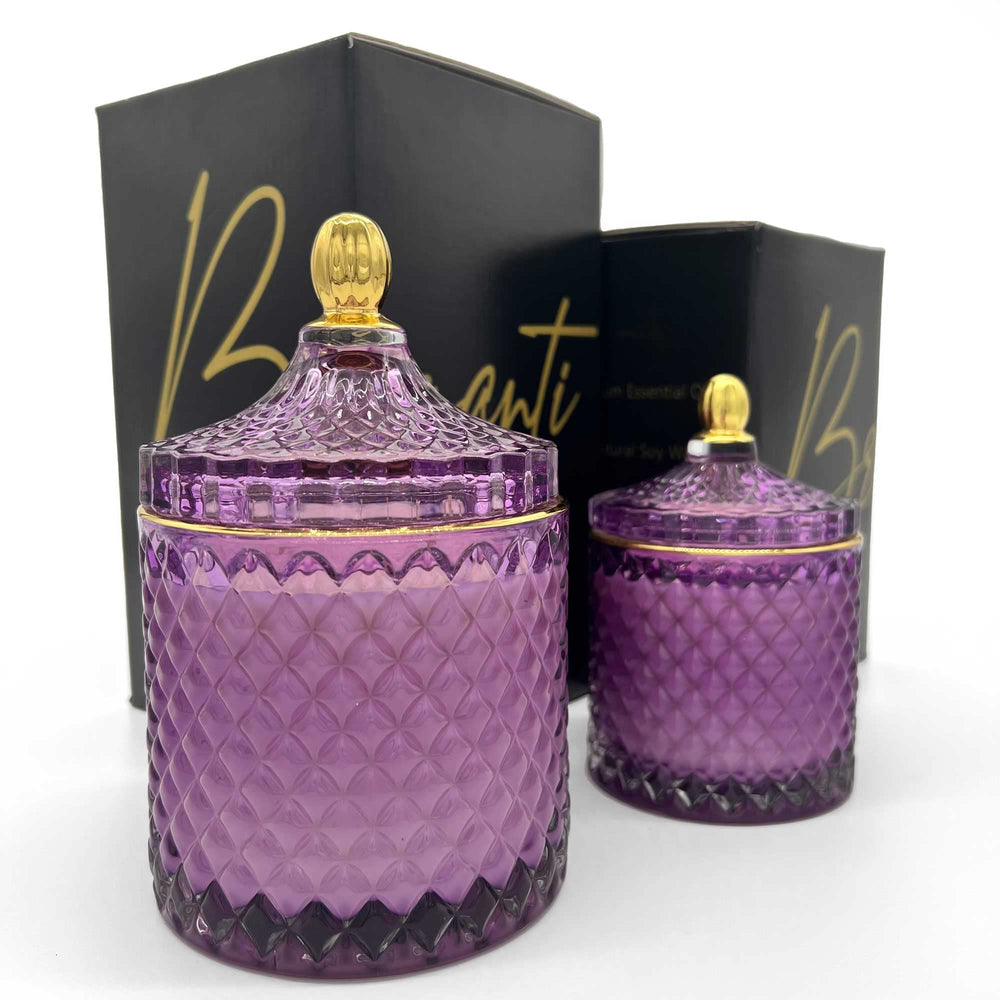 BRIGANTI Violet glass jar candle with gold rim enhances décor and scent.