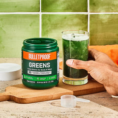 Bulletproof Greens glass with water highlighting pineapple-flavored blend