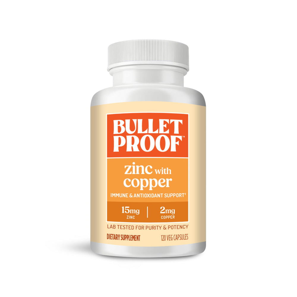 Bulletproof Zinc with Copper capsules beside a glass of water for daily immune support