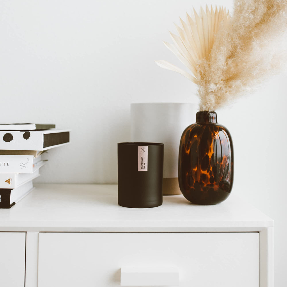 Calyan Oakmoss Amber candle in a bedroom setting for relaxing evenings