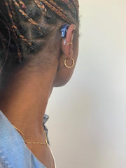 Deafmetal gold galvanized cuff on ear emphasizes fashion-forward retention.