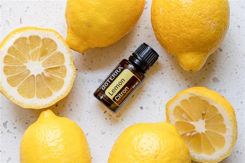 doTERRA Lemon essential oil with lemons suggesting cleaning and freshness