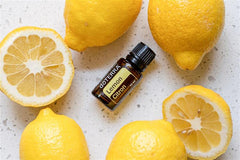 doTERRA Lemon essential oil with lemons suggesting cleaning and freshness