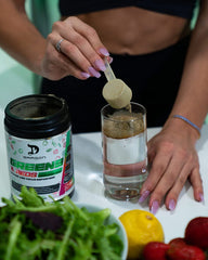 Dragon Pharma Greens and Reds being mixed into a smoothie for post-workout vitality.
