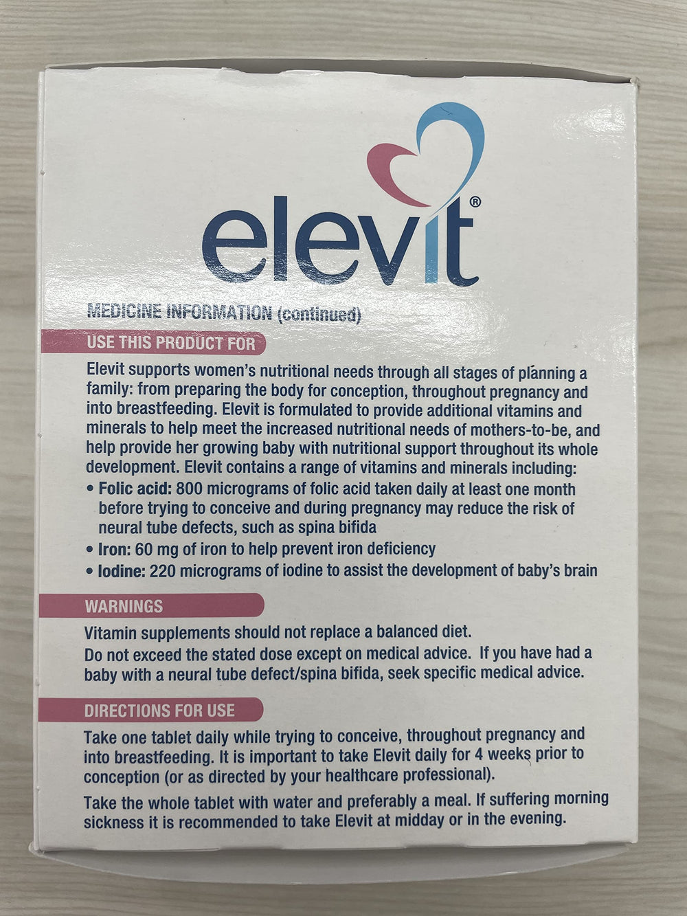 Elevit bottle and label in a wellness scene suggesting daily prenatal use.
