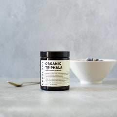 Erbology Triphala powder jar close-up emphasizes amber glass packaging preserving freshness.