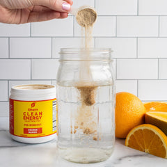 Glass being poured with Ethan's Feel Good pre-workout orange mango.