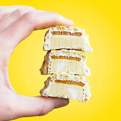 A Fit Crunch Lemon Cake bar in hand, ready for on-the-go snacking.