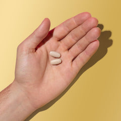 Lifestyle shot of a man taking GNC Mega Men caplets during his morning routine for daily health.