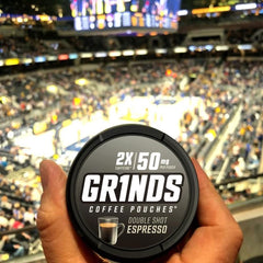 User places a GRINDS pouch under lip for on-the-go use