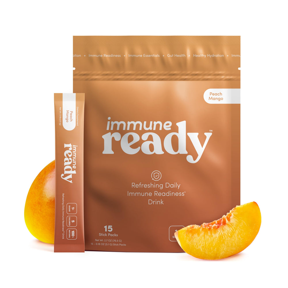Immune Ready electrolyte packet Peach Mango in a glass for refreshing hydration.