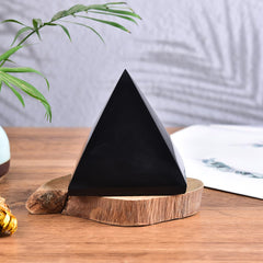 JIC Gem Black Obsidian Pyramid used as a crystal paperweight on a desk.