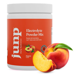 JUNP Peach electrolyte powder in a glass with ice for keto-friendly hydration.
