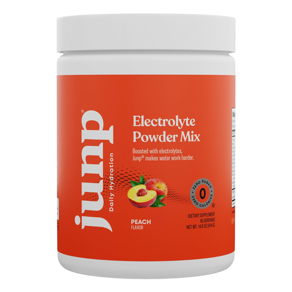 Scoop of JUNP Peach electrolyte powder beside a shaker for post-workout hydration.