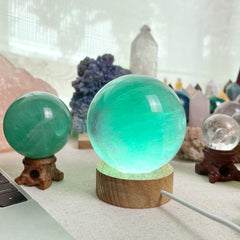 KINO green fluorite sphere demonstrates energy flow in a desk setup.