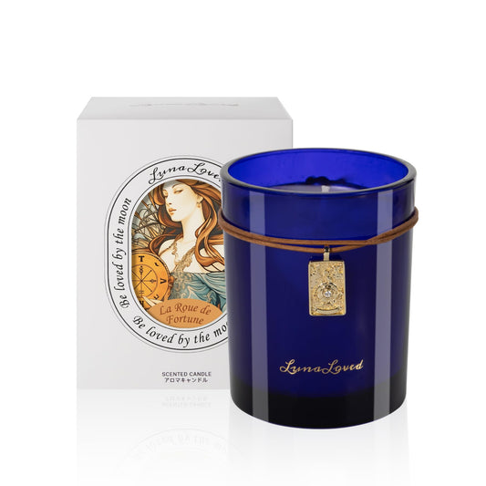 LunaLoved Wheel of Fortune blue glass candle enhances ambience with wood and citrus notes.