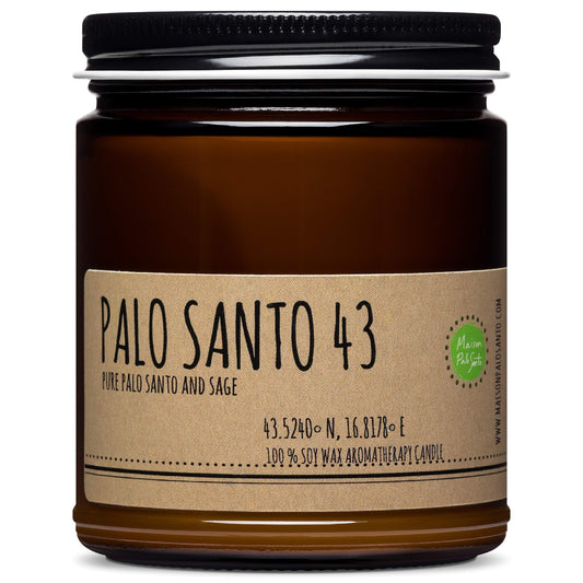 Maison Palo Santo candle glowing softly to create a calming ambiance.