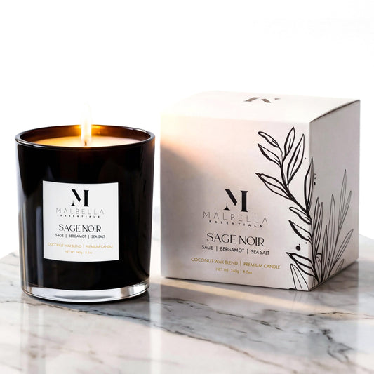 Sage Noire candle in a glossy glass vessel emitting ambient glow by Malbella Essentials.