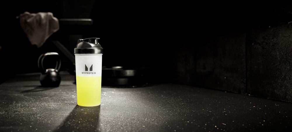 Lemon Lime flavor bottle beside water and sportswear for training