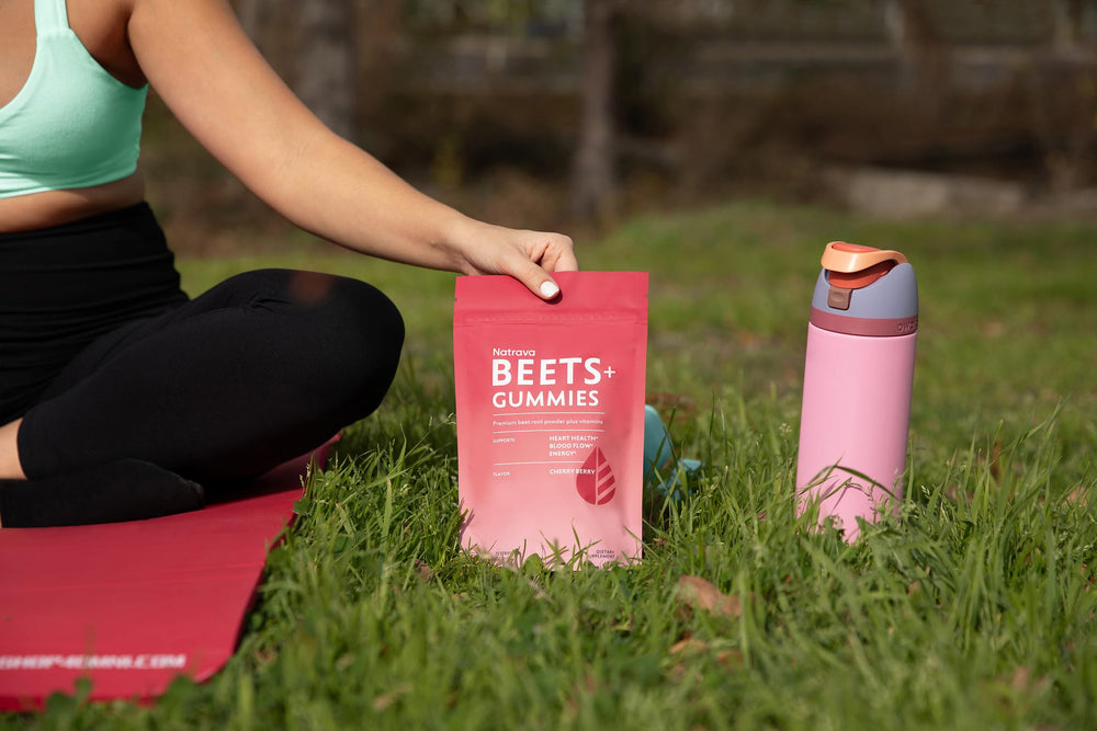 Natrava Beets+ Gummies with glass of water for daily intake.