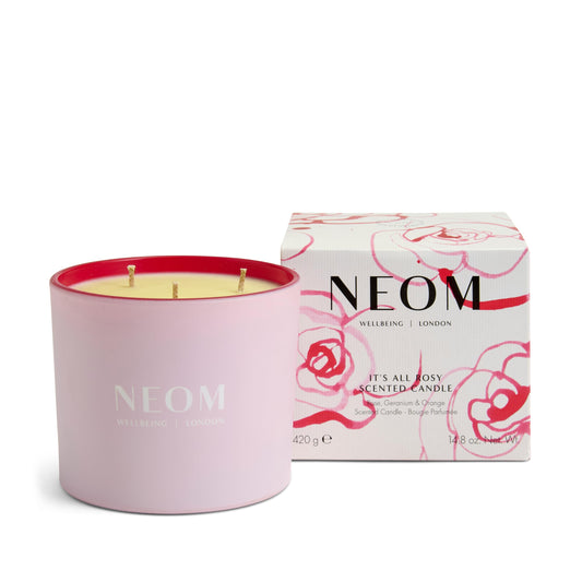 NEOM It's All Rosy Candle three-wick lit for warm ambiance.