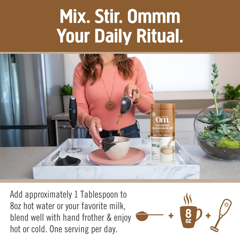 Spoon and mug show Om Mushroom Superfood Coffee Latte Blend powder mixing easily.