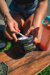 PEScience Versalyte Charged packets beside a bottle for on-the-go hydration.