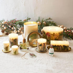Rosy Rings Forest Round Candle features birch twigs and fir needles as decor accents.
