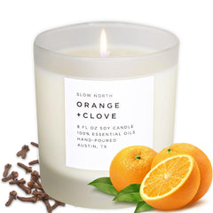 Slow North Orange and Clove Candle in a frosted jar enhances ambiance with citrus-spice aroma.