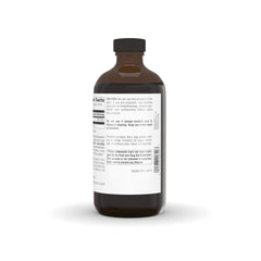 Measuring dosage with a spoon beside the Source Naturals bottle