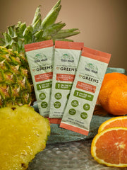 Terra Origin greens powder dissolving in a glass of water for quick hydration.