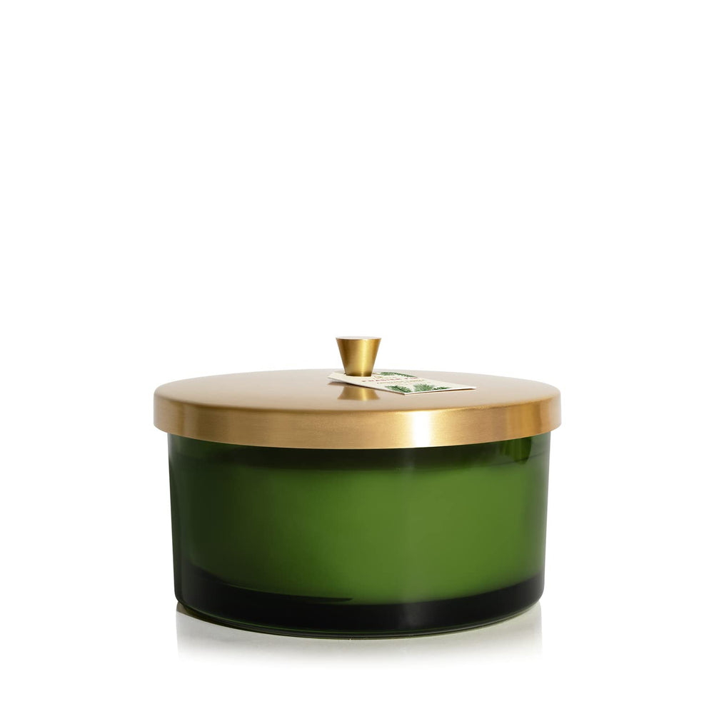 Thymes Frasier Fir candle with green glass vessel for cozy ambiance.