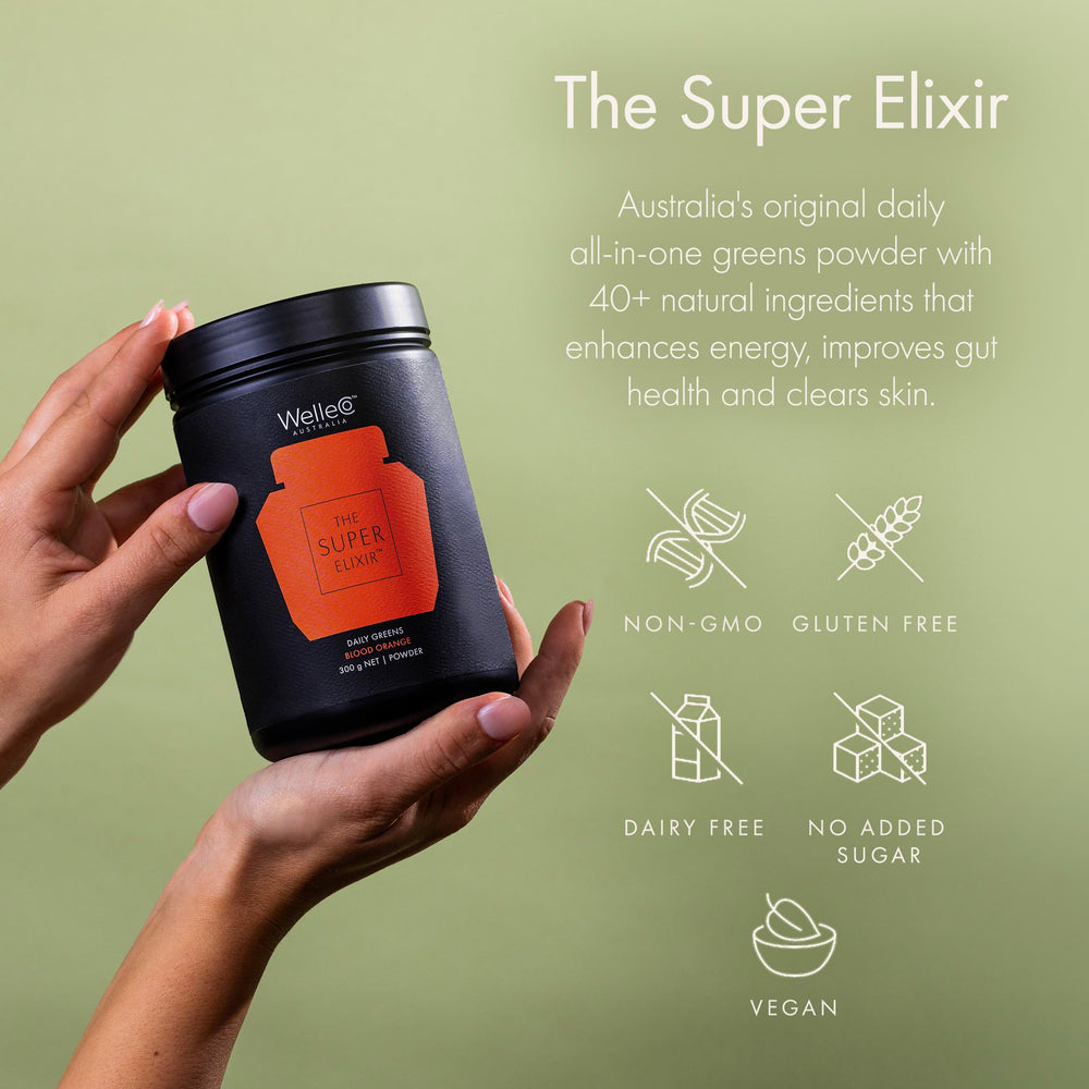 Glass with prepared WelleCo The Super Elixir drink showing a vibrant, inviting color
