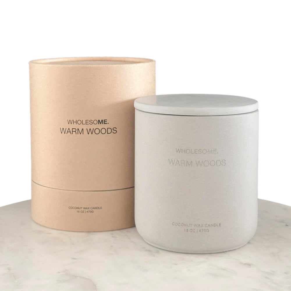 WHOLESOME Warm Woods candle in a concrete jar close-up for cozy living spaces.