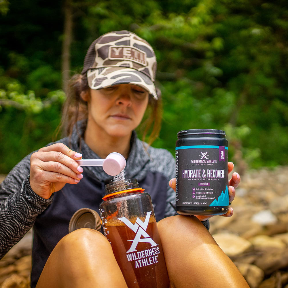Wilderness Athlete Hydrate & Recover scoop dissolving in water for quick mixing