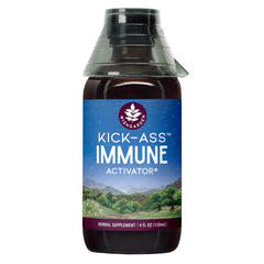 WishGarden Kick-Ass Immune Activator bottle with herbal blend on desk.