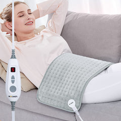 WOOMER extra-large heating pad on bed provides soothing warmth for full-body relief.