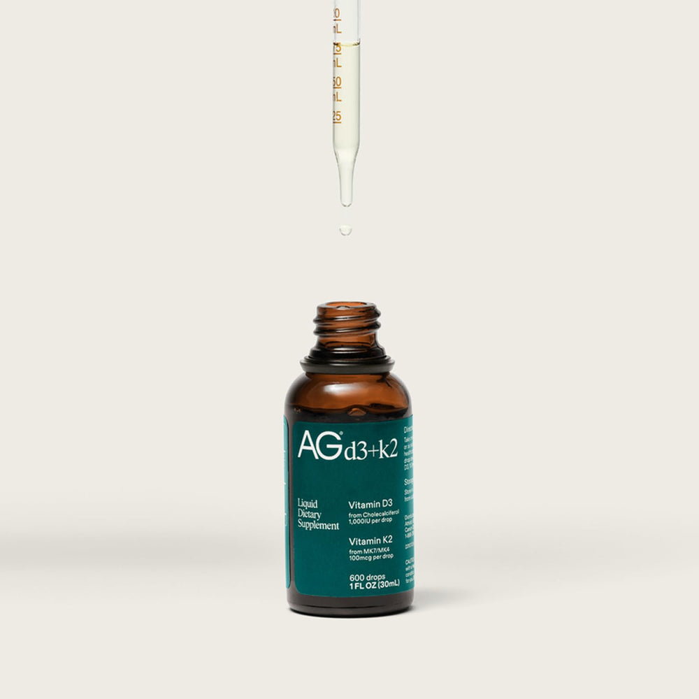 AG1 D3+K2 drops bottle label highlights vegan, non-GMO ingredients.