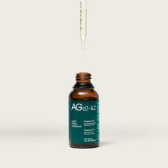 AG1 D3+K2 drops bottle label highlights vegan, non-GMO ingredients.