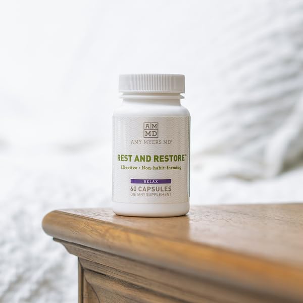 Rest and Restore bottle with glass of water beside bed for bedtime routine.