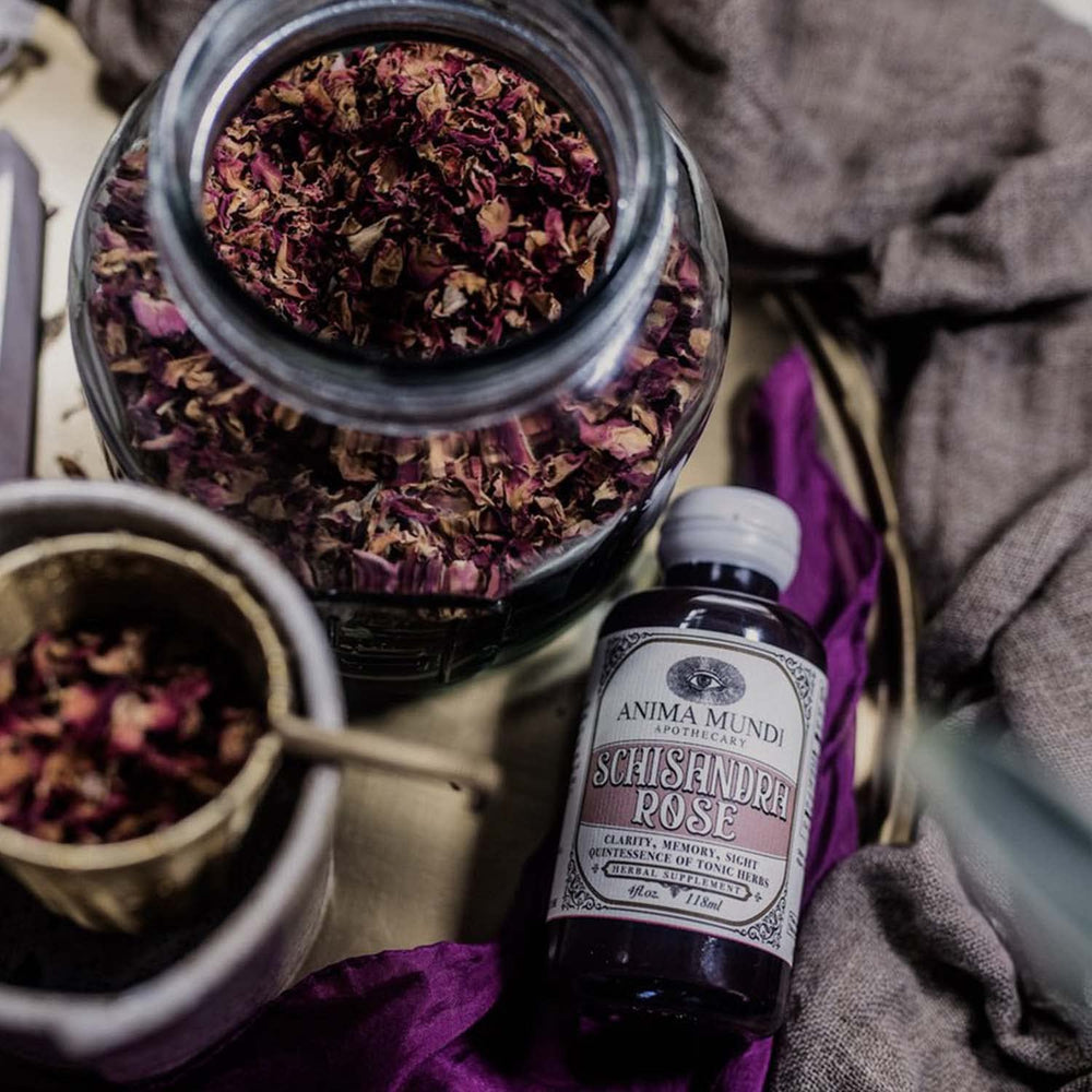 Pouring Anima Mundi Schisandra Rose Elixir into a glass for a ritual
