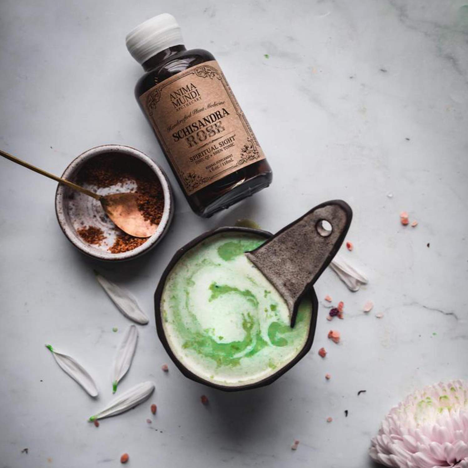 Rose petals and elixir in a glass, inviting a soothing tea addition.